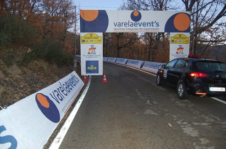 Señalización de carretera en evento automovilístico con el logo de Varela Events